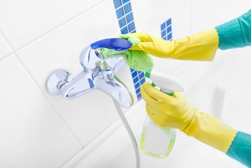 Cleaner sanitising high-touch surfaces in a shared hallway